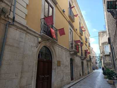 Imbocchiamo quindi via di Porta Robustina e, dopo poche decine di metri, sulla destra notiamo un edificio a tre piani con la facciata tinteggiata di giallo e un robusto portone in legno